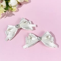 Detalle de pinzas para el cabello con lazo de seda blanca con lunares y diamantes de corazón - Beige