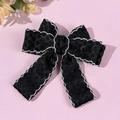 Detalle de un lazo negro grande para el pelo con bordes blancos y texturas de leopardo - Estilo con Estampado de Leopardo / Negro