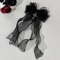 Detail der gotischen schwarzen Organza-Schleife mit Silberkreuzen und langen Bändern - Schwarz