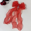 Détail du nœud papillon en organza rouge avec croix argentées et longs rubans pendants - Rouge