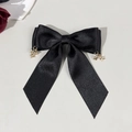 Detail van een zwarte satijnen strik haarklem met decoratieve gouden sterhangers - Sterhanger Grote Lange Stijl (4#)