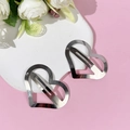 Gros plan de deux pinces à cheveux coeur en argent poli sur fond décoratif rose et blanc - 3#