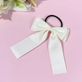 Détail d'un chouchou à nœud en satin crème avec élastique noir et finition soyeuse - Beige
