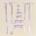 Détail d'un lot de 8 accessoires de coiffure violets avec de longs rubans et nœuds - Violet