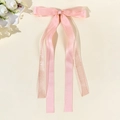 Vue détaillée du nœud papillon en tulle rose avec de longs rubans et texture en mousseline - Rose