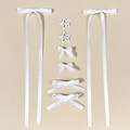 Flat lay of an 8-piece set featuring white satin ribbon bows and star hair clips - White