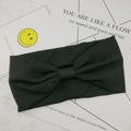 Primer plano detallado de una diadema de punto acanalado negro con un diseño de nudo central - Negro