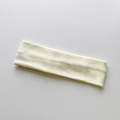 Primer plano de la diadema de punto crema mostrando la textura de canalé y la elasticidad - Beige Estrecho Cepillado