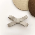 Close-up of light beige ribbed ribbon bow hair clip with textured fabric details - Gray