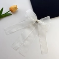 Detailansicht der weißen Organza-Schleifenspange mit langen Bändern auf grau - Weiße Schleife Haarspange