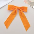 Detailansicht der leuchtend orangefarbenen Samtschleife mit eleganten langen Bändern - Orange