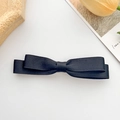 Detailed macro view of black layered ribbon bow hair clip with textured grosgrain fabric - Black Bow