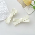 Détail de deux barrettes à cheveux en forme de nœud crème en tissu côtelé - Beige
