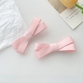 Detail of pink ribbon bow hair clips set on a clean background with aesthetic props - Pink