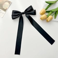 Detalle de un gran lazo de satén negro para el pelo con cintas largas y elegantes - Negro