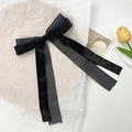 Detalle de elegante pasador de pelo en organza negra y cinta brillante con cintas - Negro