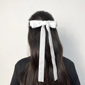 Dettaglio del fiocco per capelli in velluto bianco con lunghi nastri su capelli castani - Bianco