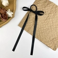 Elegante coletero con lazo de satén negro y cintas largas sobre papel artesanal texturizado - Negro