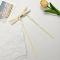 Detailansicht der beigen Samt-Haarschleife mit langen Bändern auf französischem Hintergrund - Beige