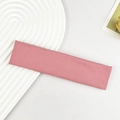 Detailaufnahme eines rosa gerippten Yoga-Stirnbands auf einem weißen Tablett - Rosa