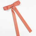 Detailed view of large coral velvet bow hair clip with elegant long flowing ribbons - Satin Orange Pink