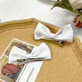 Close-up of dual white ribbon bow hair clips with silver metal alligator grip - White