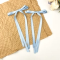 Détail de pinces à cheveux à nœud en satin bleu clair avec de longs rubans élégants - Bleu