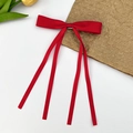 Détail de la pince à cheveux noeud rouge avec longs rubans et texture satinée lisse - Rouge