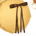 Detail of dark brown satin double-layer bow hair clip with long ribbons on a display tray - Dark Brown