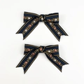 Dettaglio del fermaglio a fiocco etnico ricamato con motivi floreali blu navy - Blu navy
