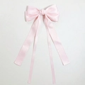 Detail of pink satin bow hair clip featuring long flowing ribbons on white background - Light Pink