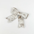 Detailopname van de champagne fluwelen strik met luxe zachte textuur en knoopdetails - Abrikoos