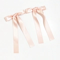 Close-up of a pair of elegant champagne pink satin ribbon bow hair clips with long streamers - Orange Pink