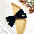 Dettaglio del fiocco in velluto nero con cuore dorato e fascia centrale luccicante - Nero