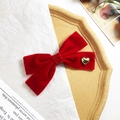 Dettaglio del fermaglio a fiocco in velluto rosso con cuore dorato e nastro glitter - Rosso