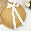 Détail d'un nœud papillon en satin blanc élégant avec de longs rubans sur un socle - Blanc