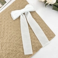 Elegant white velvet bow hair clip with long streamers on a vintage background - White