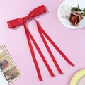 Elegant red satin bow hair clip with long ribbons on a pink decorative background - Red