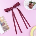 Elegant wine red satin ribbon bow hair clip with long streamers on pink background - Burgundy
