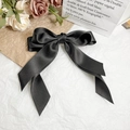 Detail of elegant black satin bow hair clip with long ribbons on vintage background - Black