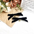 Close-up of black velvet bow hair clips with gold bell charms on rustic floral backdrop - Black Velvet Bell Bow (1#)