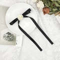 Dettaglio di un fiocco in seta nera con rosa in tessuto crema su un piatto decorativo - Fermaglio per Capelli Fiocco Rosa Nera Streamer Lungo / Nero