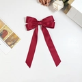 Detail of wine red satin bow hair clip with long ribbons and elegant silky texture - Burgundy