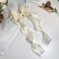 Detail van een crèmewitte satijnen strik haarclip met lange soepele elegante linten - Crèmewit Satijn Stijl / Beige