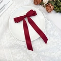 Detailed view of elegant burgundy satin bow hair clip with long ribbons on lace background - Burgundy