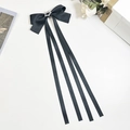 Detalle de horquilla con lazo largo de satén negro, estrella brillante y cintas colgantes - Negro