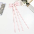 Detalle de pinza de pelo con lazo de satén rosa, diamantes de estrella y cintas largas de seda - Rosa