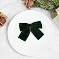 Detailed close-up of dark green velvet bow hair clip with vintage texture on a ceramic plate - Dark Green