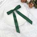 Detailed view of forest green satin bow hair clip with long ribbons on a lace background - Dark Green