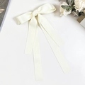 Close-up of cream satin double bow hair clip with long ribbons on marble surface - Beige